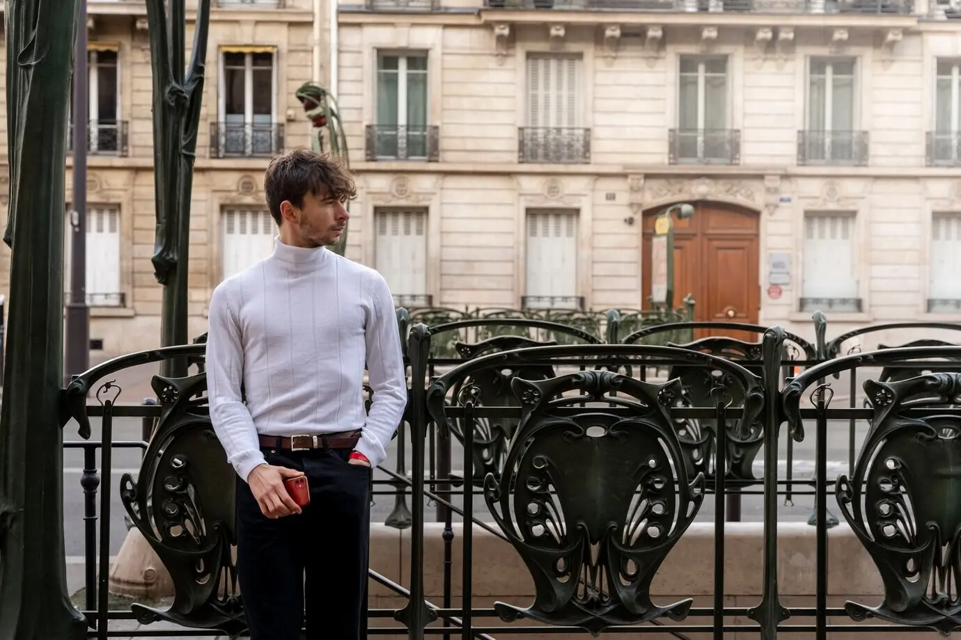 Молодой французский мужчина позирует у входа в метро